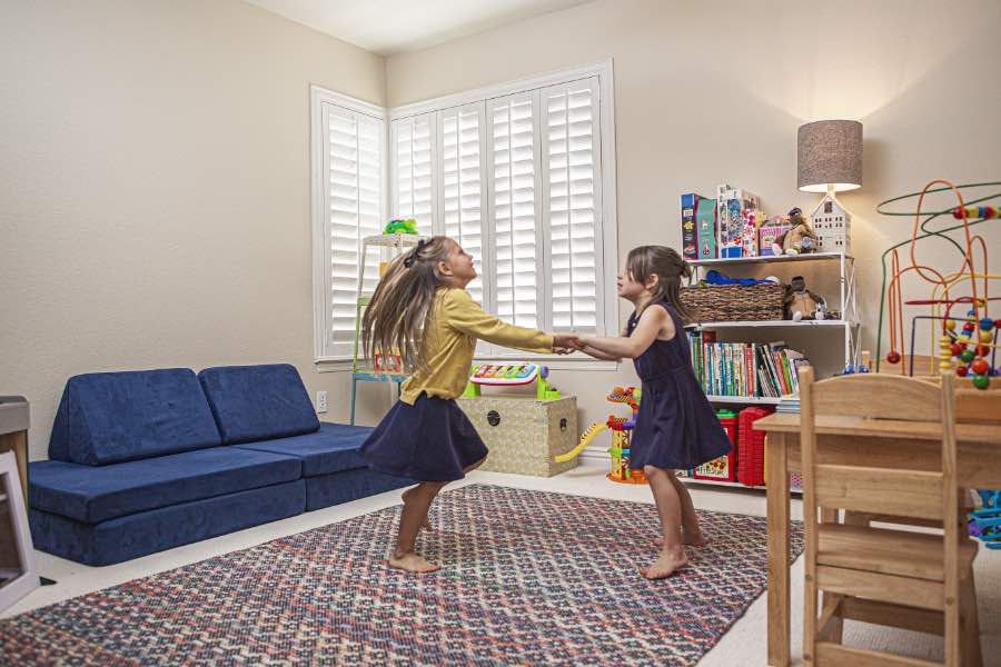 Choose Polywood shutters for durable, kid-friendly great room window treatments in Boston. Polywood shutters on multiple windows in a sitting area