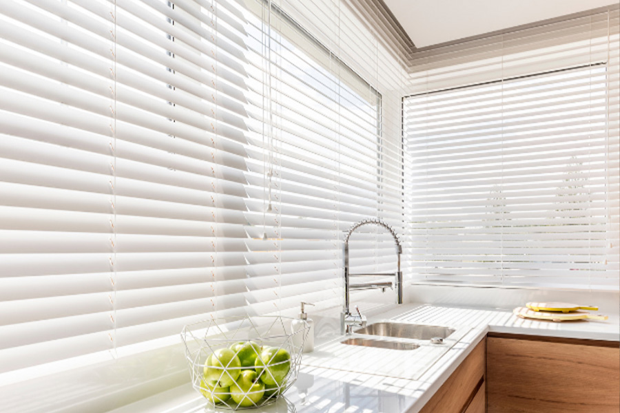White Polywood faux wood blinds on a large kitchen window