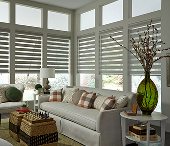 Holiday decor in a living room with blinds behind a couch area