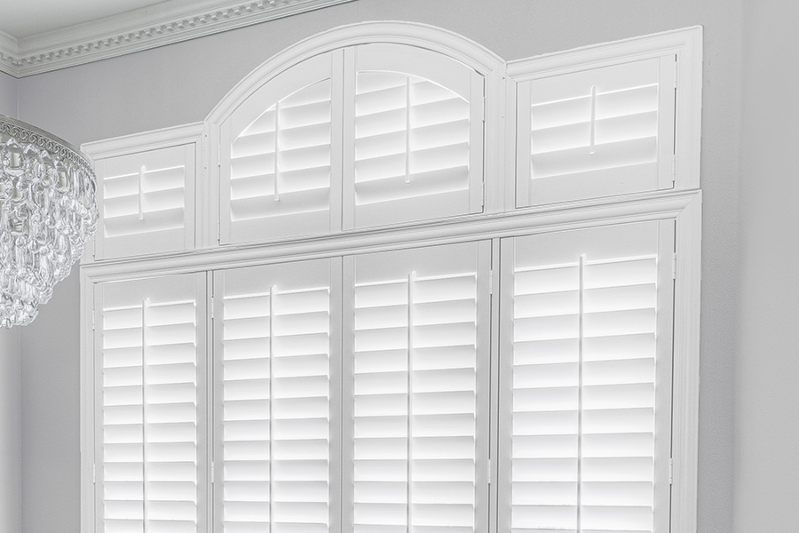 Customize your Palladian windows with white Polywood shutters in Boston. White Polywood Palladian windows in a dining room.