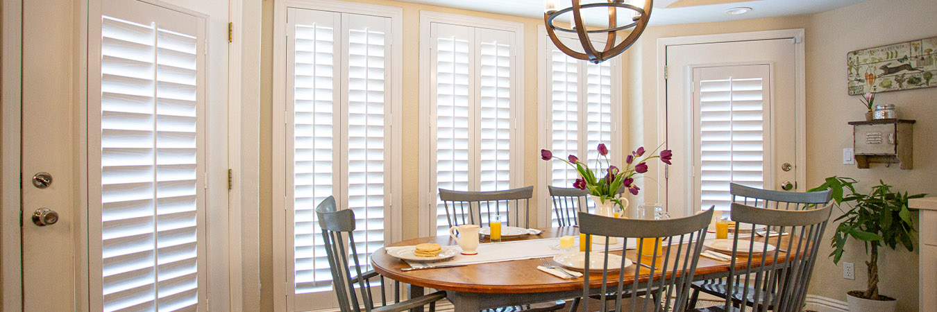 White Polywood shutters within a large breakfast nook.