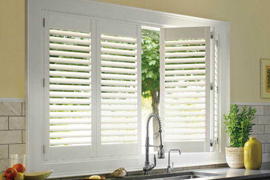 Polywood shutters are built to withstand the test of time in Boston. White Polywood shutters above a kitchen sink.