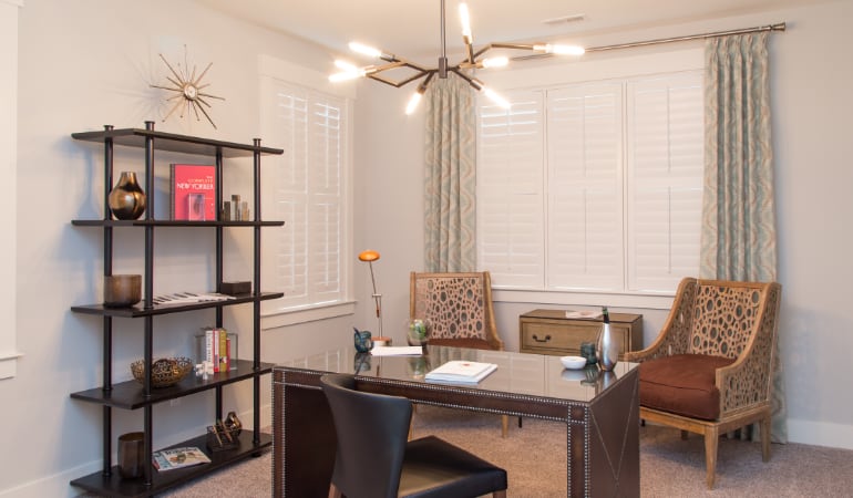 Picking the right window treatments can result in an increase in natural light. Boston home office with plantation shutters.