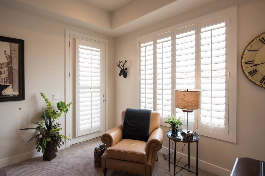 Premium hardwood shutters are a great pet-friendly window treatment. White shutters in a corner of a living room