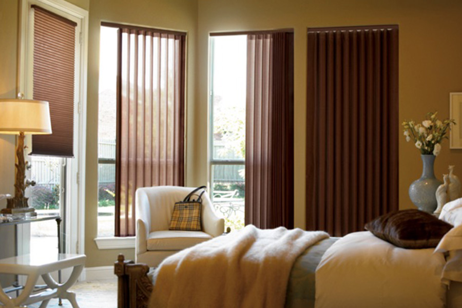 Choose durable and high-quality fabric or vinyl vertical blinds in Boston. Maroon fabric vertical blinds inside a bedroom