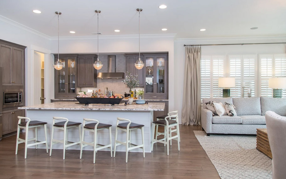 Illuminate your home with custom interior shutters in Boston. White arched shutters in a white kitchen with lots of light.