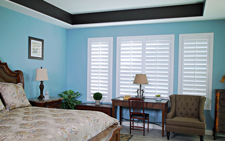 Polywood shutters provide insulation for the perfect temperature all year long in Boston. Polywood shutters in a bedroom.