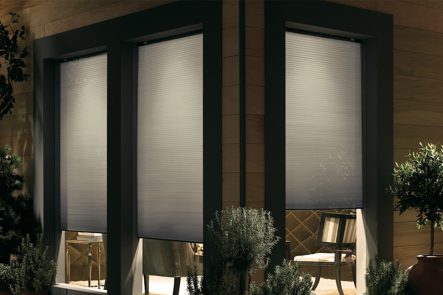 Cellular shades are modern and stylish window treatments for your home in Boston. Dark gray cellular shades displayed from the exterior of a home.