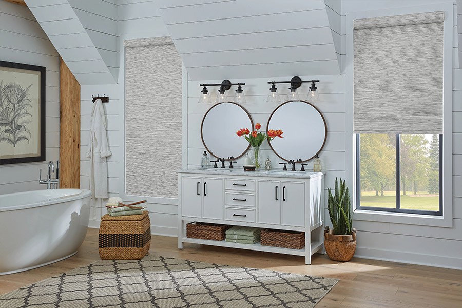 Slim-profile roller shades easily fit shallow windows in your Boston home. Gray patterned roller shades on bathroom windows